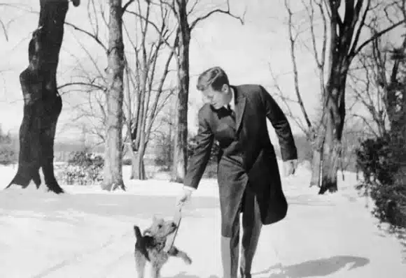 President John F. Kennedy playing with his dog Charlie